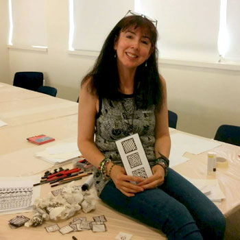 Brenda Coyle sitting with artwork from Relaxation Through Art